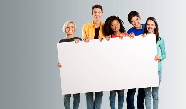 happy young men and women holding blank banner - Photo, Image