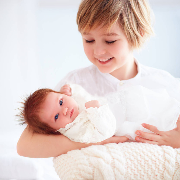 happy elder brother holding his newborn little sister - Valokuva, kuva