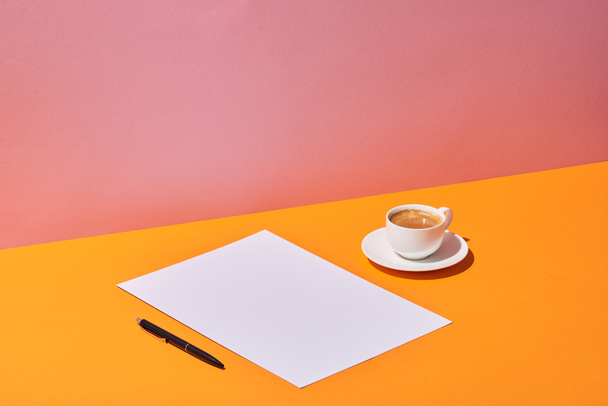 paper sheet, pen and coffee cup on yellow desk and pink background - Foto, immagini