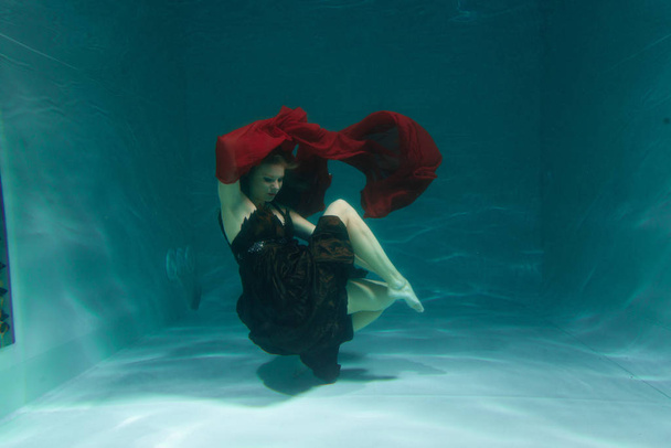 hermosa mujer buzo libre nadando en vestido de noche marrón largo bajo el agua solo en la profundidad
 - Foto, imagen