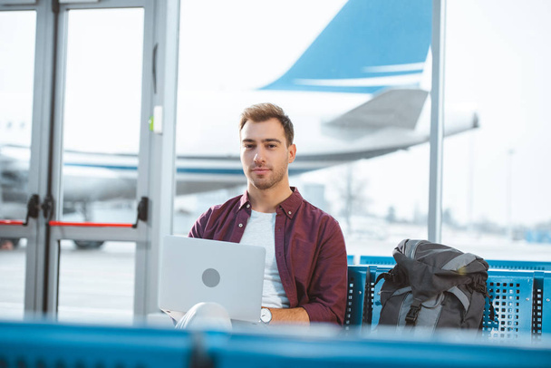 handsome man using laptop while waiting in departure lounge  - Photo, Image