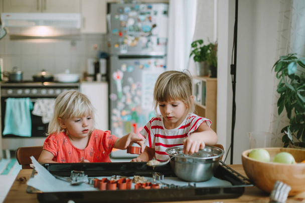 two cute little sisters cooking at home - Photo, Image
