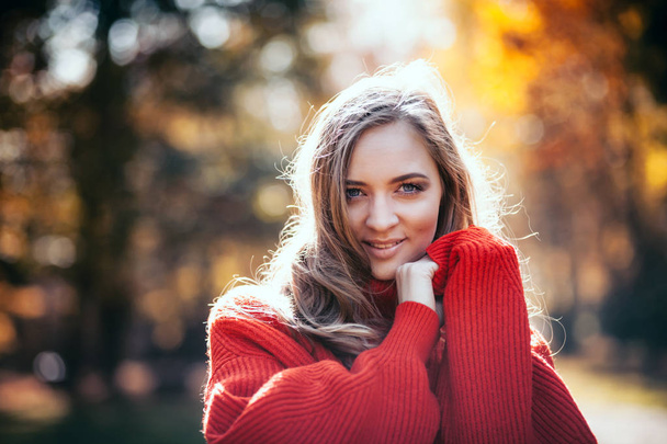 Natural young woman in soft warm knitted sweater walking outdoors, autumn and spring - Foto, imagen