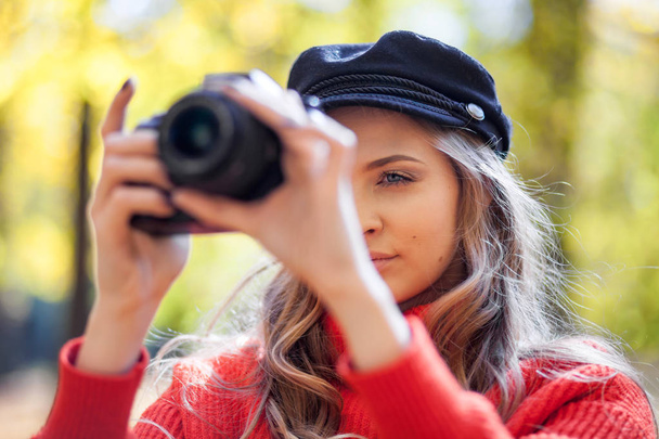 Young woman having fun with camera making photos at green park - Фото, изображение