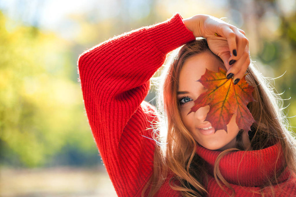 Natural woman holding colorful autumn leaf in bright sunlight - Foto, Imagem