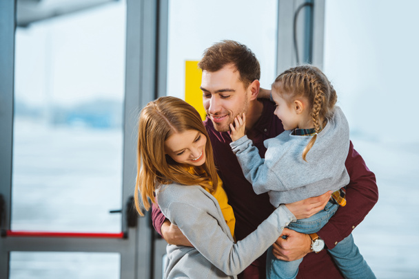 happy family smiling while hugging in airport  - Foto, afbeelding