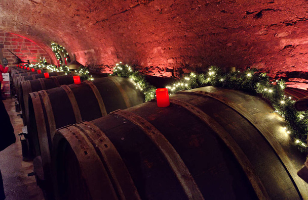Винні бочки в старому винному підвалі з червоними свічками і казковими вогнями
 - Фото, зображення
