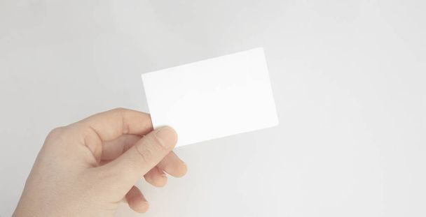 Pessoa mão segurando cartão de papel em branco isolado fundo branco
 - Foto, Imagem