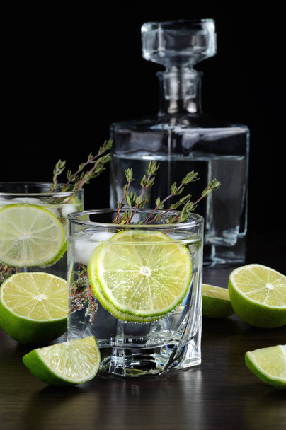 Cocktail valkoisella rommilla ja tonicilla, viipale limeä ja timjamia
 - Valokuva, kuva