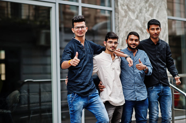 Group of four indian mans, wear on casual clothes, posed outdoor at street of India. Shows thumb up. - Foto, immagini