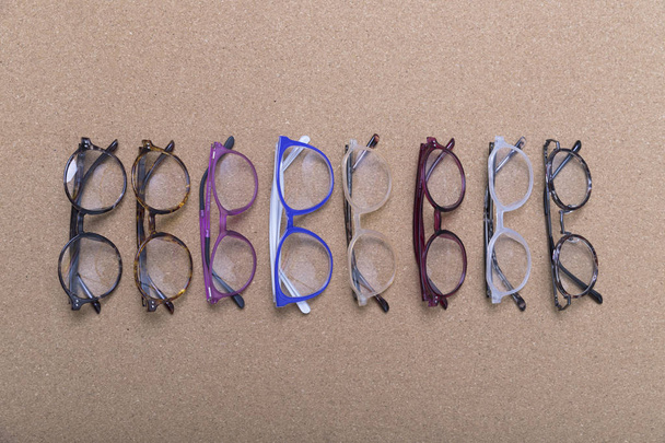 Otto occhiali diversi su tavola di sughero
 - Foto, immagini
