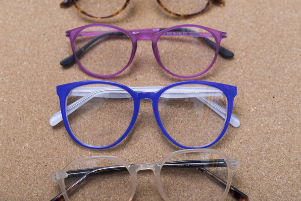 Eri silmälasien kehykset korkkilaudalla
 - Valokuva, kuva