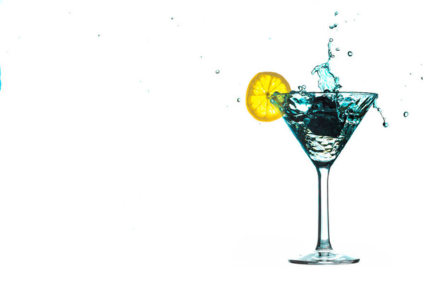 Eau de cocktail bleue éclabousser dans le verre avec du citron Isolé sur fond blanc
 - Photo, image