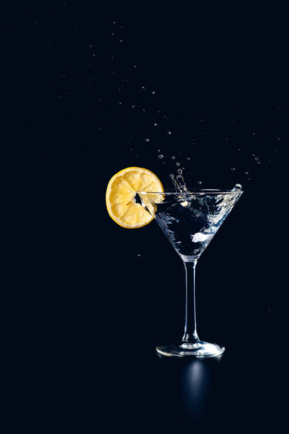 Koktajl wody powitalny napój w szkle z cytryny na białym na czarnym tle - Zdjęcie, obraz