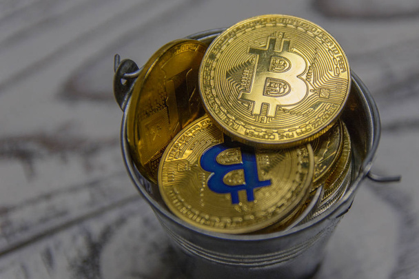 golden bitcoin and other crypto currency in toy metal bucket - Foto, imagen