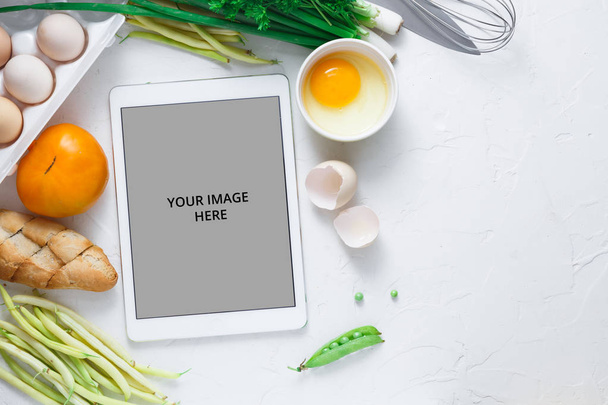 Cooking recipes on ipad with vegetables on background, copy space - Photo, Image