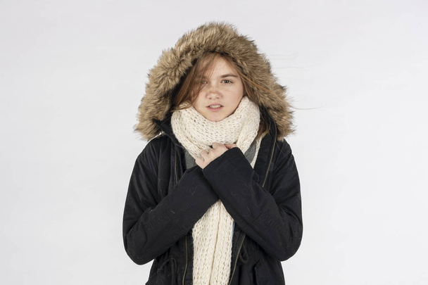 Una hermosa modelo adolescente rubia posando con un abrigo de invierno en un ambiente de estudio - Foto, imagen