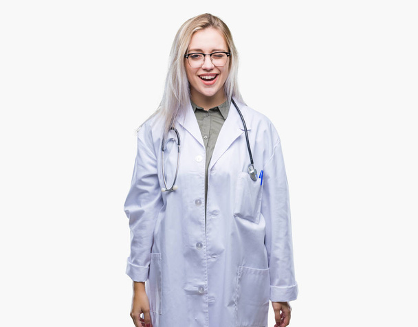 Молода блондинка лікарка над ізольованим тлом підморгує дивлячись на камеру з сексуальним виразом, веселим і щасливим обличчям
. - Фото, зображення