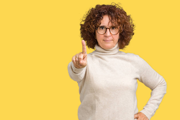 Bella donna anziana medio ager indossa maglione dolcevita e occhiali su sfondo isolato Indicazione con dito in su e espressione arrabbiata
 - Foto, immagini