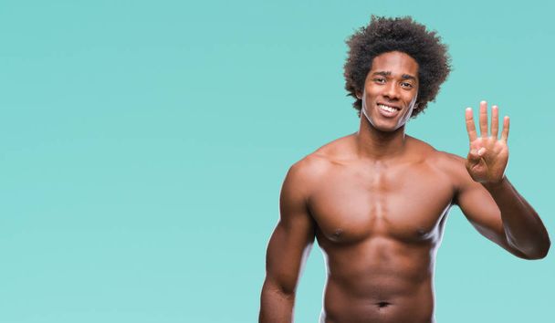 Afro Amerikaanse shirtless man naakt lichaam tonen over geïsoleerde achtergrond weergeven en met de vingers omhoog nummer vier terwijl lacht zelfverzekerd en blij. - Foto, afbeelding