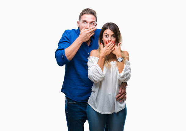 Young couple in love over isolated background shocked covering mouth with hands for mistake. Secret concept. - 写真・画像