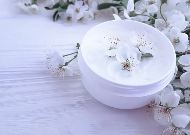 blooming cherry, cream cosmetic on wooden background - Φωτογραφία, εικόνα