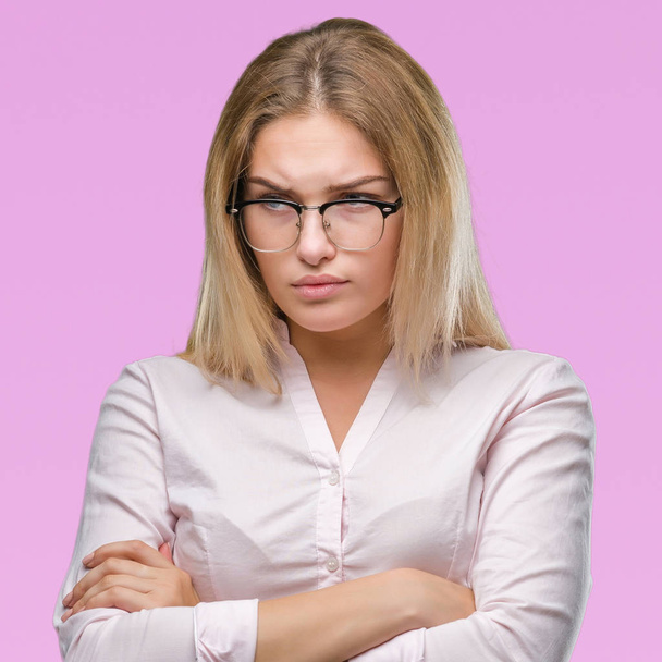 Young caucasian business woman wearing glasses over isolated background skeptic and nervous, disapproving expression on face with crossed arms. Negative person. - Foto, imagen