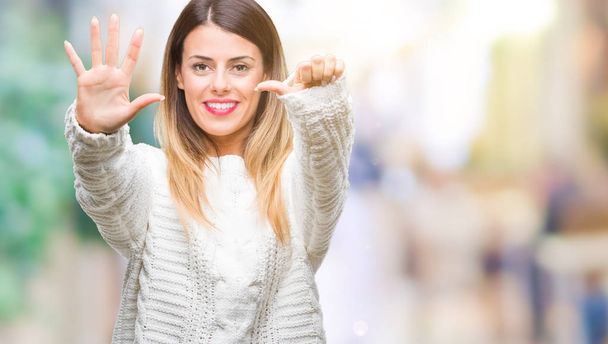 Молодая красивая женщина случайный белый свитер на изолированном фоне показывая и указывая пальцами номер шесть, улыбаясь уверенно и счастливо
. - Фото, изображение