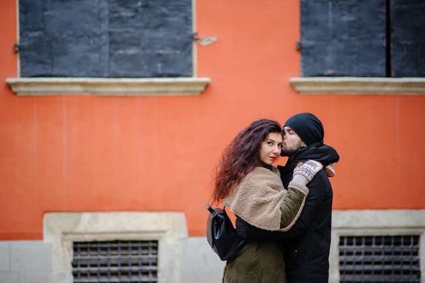 Young happy couple of lovers at beginning of love story - Handsome man whispers soft kisses in beautiful woman ear - Fall fashion concept with boyfriend and girlfriend on a cold vintage filtered look - Foto, Bild