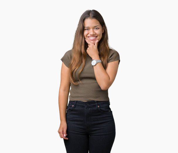 Young beautiful brunette woman over isolated background looking confident at the camera with smile with crossed arms and hand raised on chin. Thinking positive. - Foto, immagini