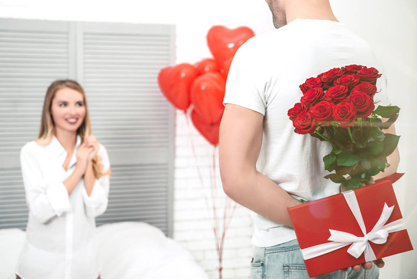 man holding gifts for his girlfriend behind a back, valentines day concept - Photo, image