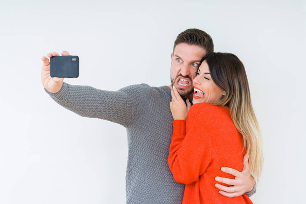 Beautiful young couple in love, kissing and hugging each other taking a selfie picture - Foto, imagen