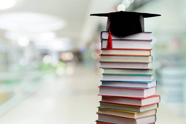 Graduation hat and stack of books - Fotó, kép