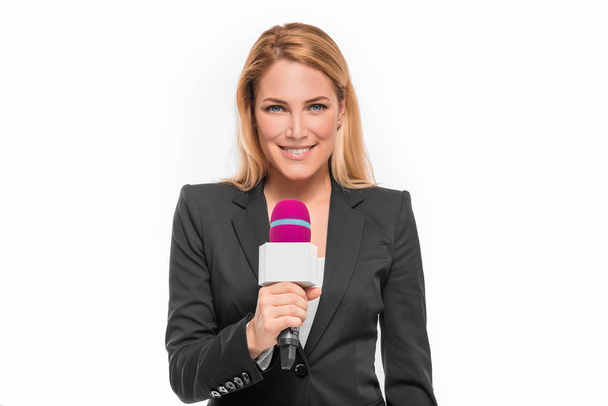 Attraente presentatore TV bionda in possesso di un microfono e indica un oggetto
. - Foto, immagini