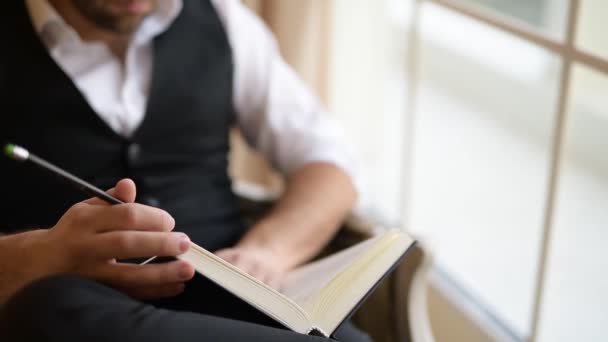 Close-up van zakenman zittend op fauteuil en gespiegeld door een boek. - Video