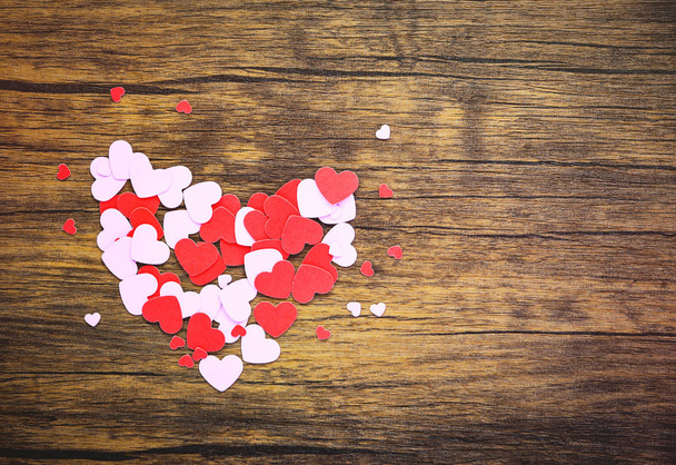 Corazón de papel sobre fondo de madera / pequeño corazón rosa y rojo Día de San Valentín para el tono amante vintage clásico madera vista superior espacio de copia
 - Foto, imagen