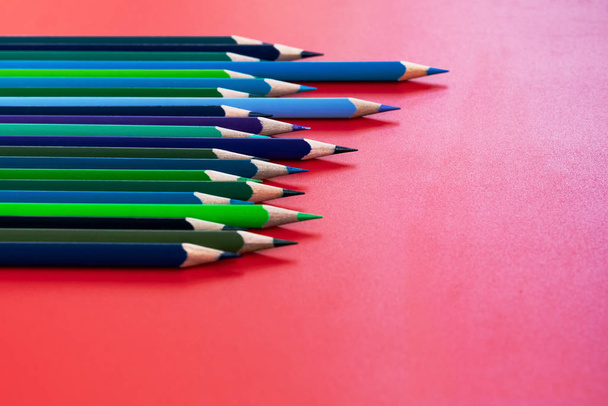 Concepto de trabajo en equipo. grupo de lápiz de color sobre fondo rojo
 - Foto, Imagen
