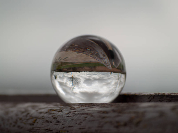 Reflejos de una calle en un parque en una bola de cristal
 - Foto, Imagen