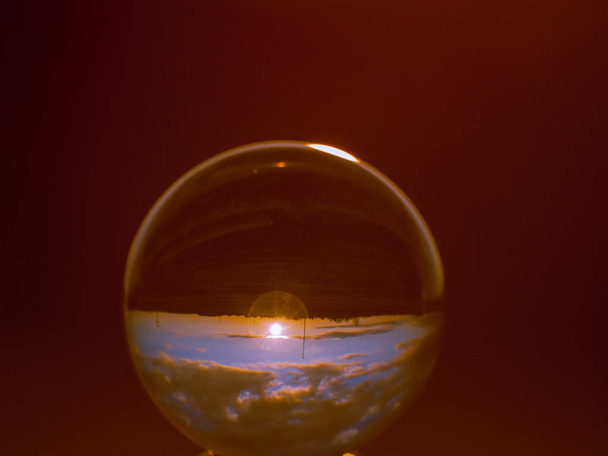 Riflessioni del tramonto in città in una sfera di cristallo
 - Foto, immagini