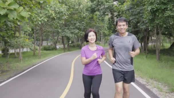 asiatische Paare mittleren Alters joggen und laufen in Park - Filmmaterial, Video