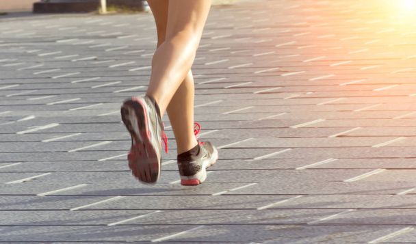 vrouwen benen snelwandelen gezonde levensstijl sport zomer stad zonsopgang weg - Foto, afbeelding
