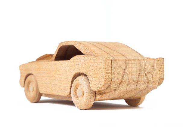 Foto van een houten auto van beuken. Speelgoed gemaakt van hout retro auto op een witte achtergrond voor geïsoleerde - Foto, afbeelding