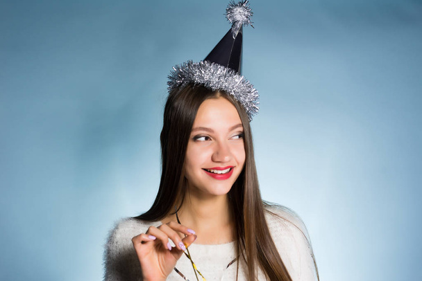 happy woman in a festive cap on a blue background - Fotoğraf, Görsel