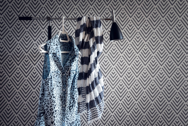 Stijlvolle kleding op moderne wallpaper achtergrond. Blauw denim vest en gestreepte sjaal. - Foto, afbeelding