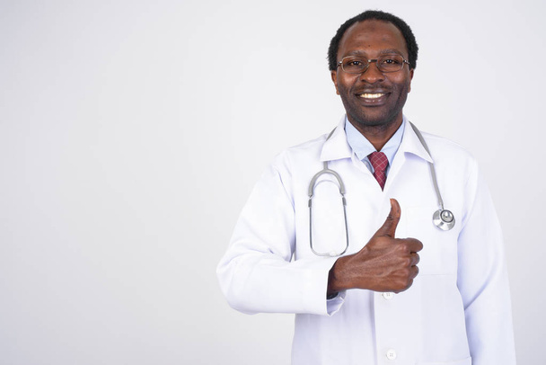Portrait of happy African man doctor giving thumbs up - 写真・画像