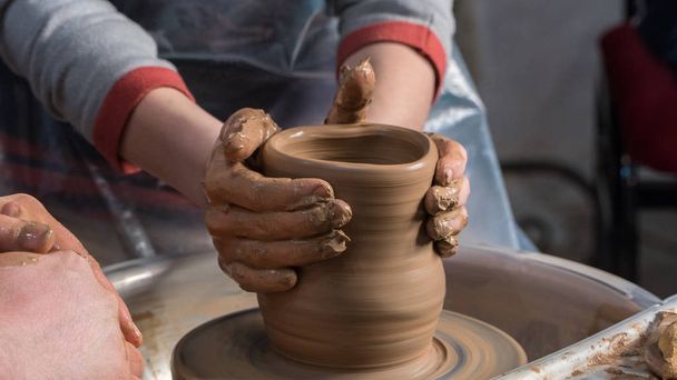 Teaching pottery to children. The teacher gives a master class in modeling - Foto, Imagen