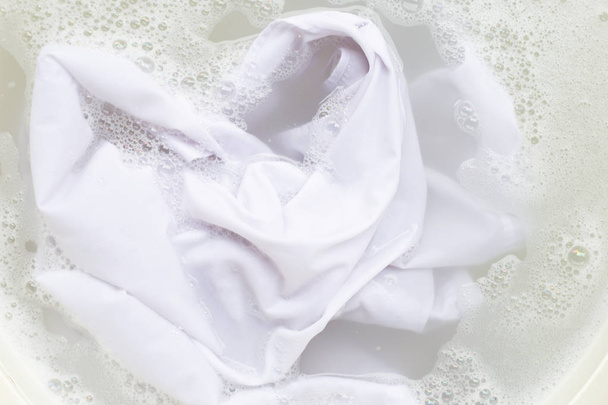 Remojar un paño antes de lavar, camisa blanca
 - Foto, imagen