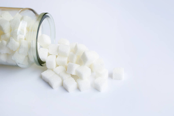 Bottiglia di vetro di cubetti di zucchero su sfondo bianco
 - Foto, immagini