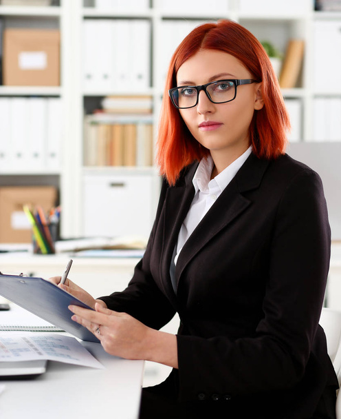 Business woman redhead office portrait sit table - Фото, изображение
