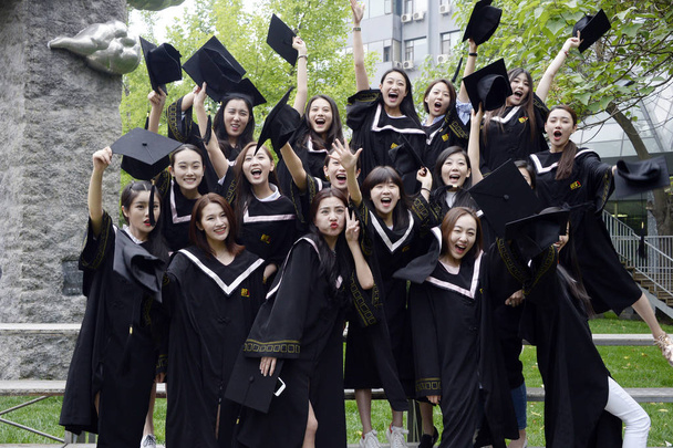 Female Chinese graduates dressed in academic gowns pose during a graduation photo shoot at Beijing Film Academy in Beijing, China, 23 May 2016 - 写真・画像
